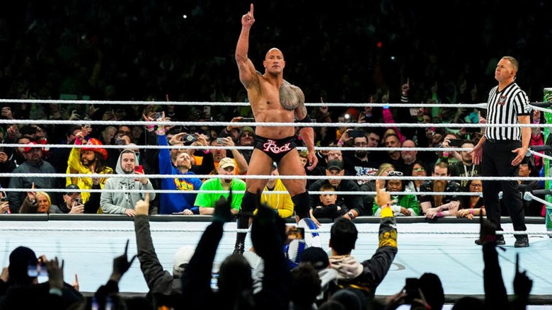 The Rock poses in the ring before hitting a People's Elbow during his match alongside Roman Reigns at WrestleMania 40.