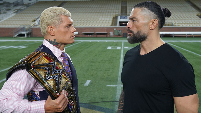 Cody Rhodes and Roman Reigns facing off on a football field