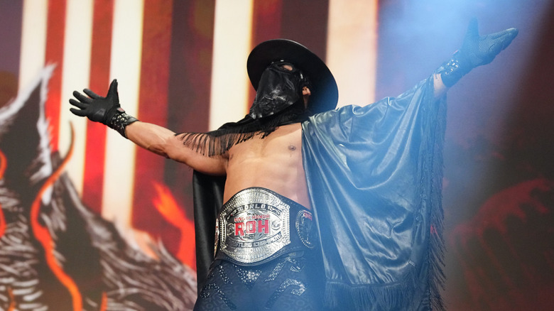Bandido poses on the stage wearing his ROH title before a match on 