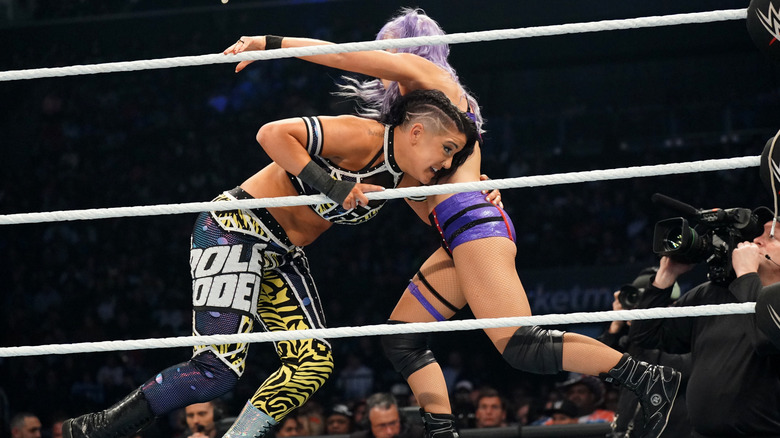 Bayley tackling Candice LeRae in a WWE ring