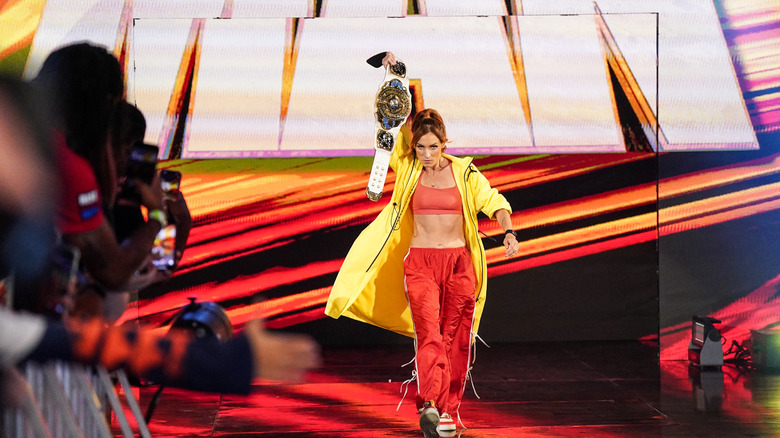 Becky Lynch holds up the IC title as she walks to the ring