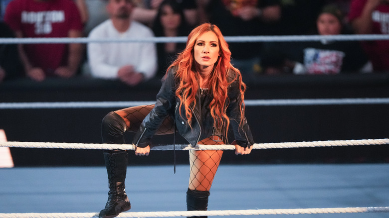 Becky Lynch looks into the crowd while holding the ropes