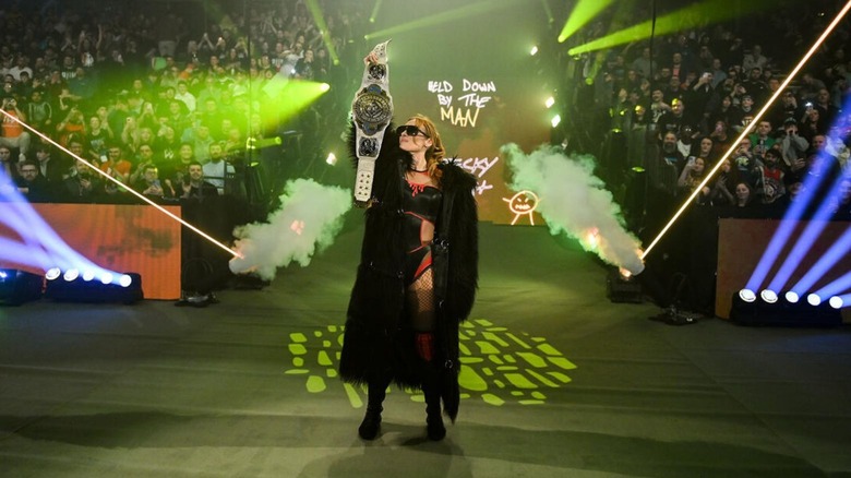 Women's Intercontinental Champion Becky Lynch poses on the stage, title held high, before a match on 