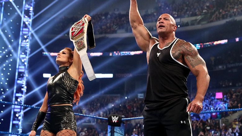 Becky Lynch and The Rock posing in the ring