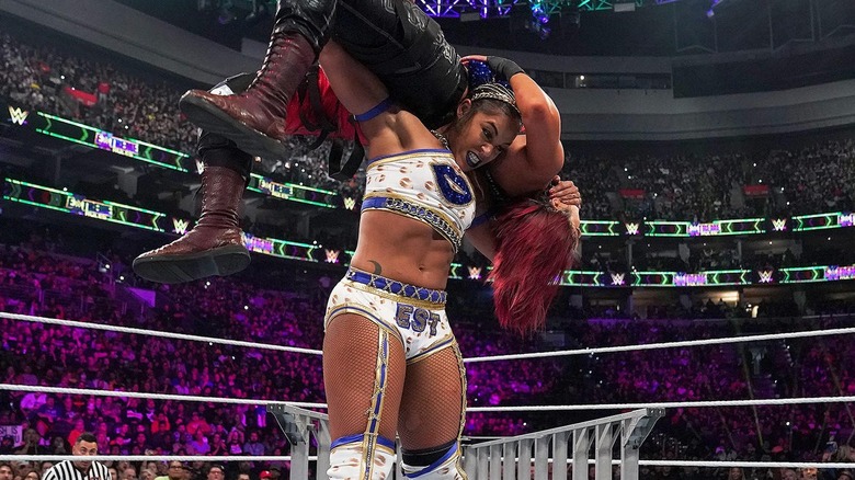 Bianca Belair carrying Bayley on her shoulders