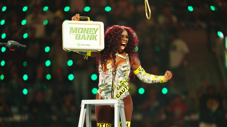 Naomi holding up the Money In The Bank briefcase