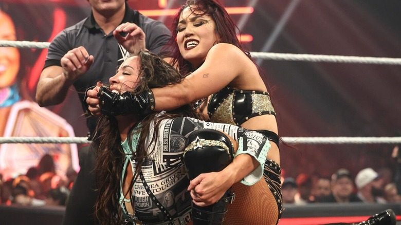 Roxanne Perez puts WWE Women's Champion Chelsea Green in a hold in the middle of the ring during a match on "WWE Raw."