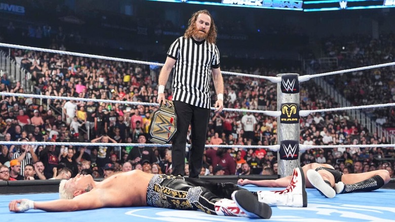 Sami Zayn holds the Undisputed WWE Championship in the ring as GUNTHER and Cody Rhodes remain laying after he refereed their title match on the June 19, 2026 edition of "WWE SmackDown."