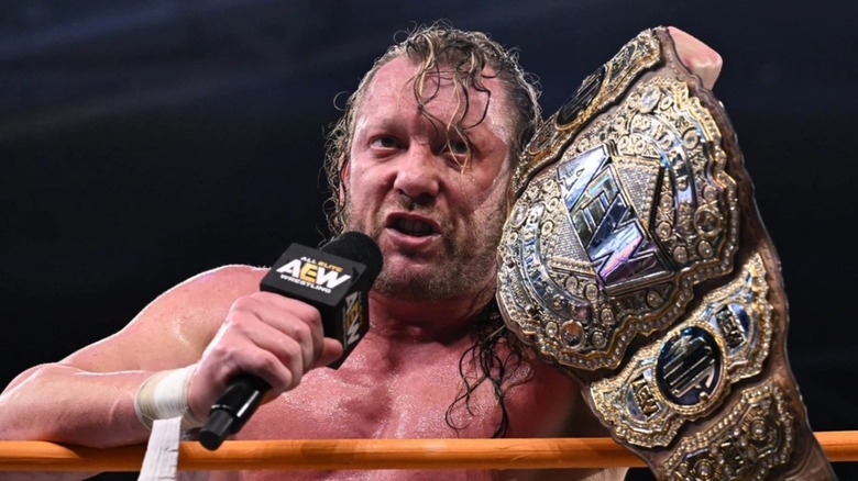 Kenny Omega holding up the AEW world title on "AEW Dynamite"
