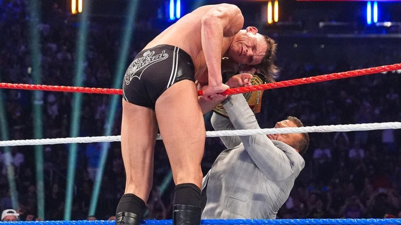 GUNTHER, hanging over the ropes, eats a title shot by Nick Aldis, during his tag team match alongside Sami Zayn against CM Punk and Cody Rhodes at WWE Saturday Night's Main Event.