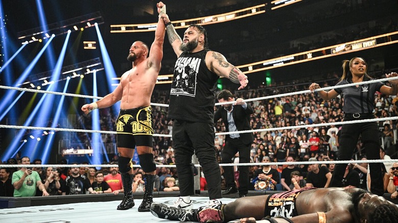Bron Breakker holds up Bronson Reed's arm as they stand above a fallen Oba Femi at WWE Sunday Night's Main Event