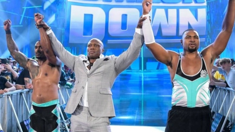 Bobby Lashley raises the hands of Montez Ford and Angelo Dawkins after a match on "WWE SmackDown."