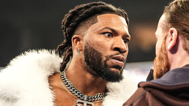 Trick Williams with an intense facial expression looking at Sami Zayn