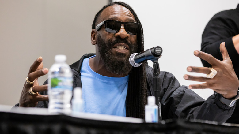 Booker T speaking at a convention with sunglasses on