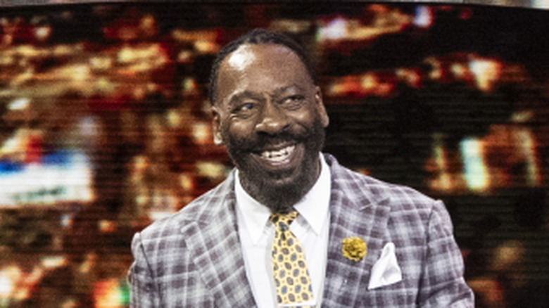 Booker T smiling as he walks out to do commentary