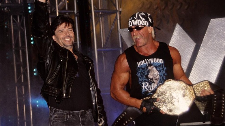 Eric Bischoff and Hulk Hogan making their way to the ring together during a WCW show.