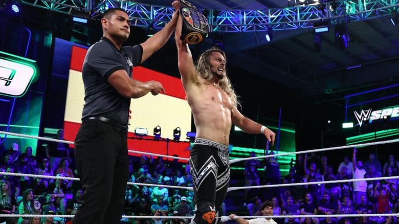 A referee raises the hand of then-WWE Speed Champion Lexis King in the ring after a victory on an episode of 