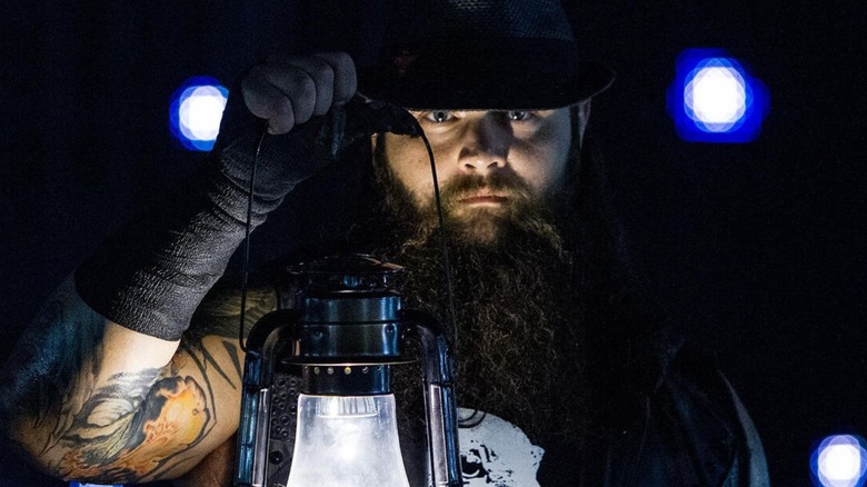 Bray Wyatt looks into the camera during his ring entrance while carrying his signature lantern.
