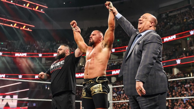 Bronson Reed and Paul Heyman hold up the arms of Bron Breakker after he scored a win on "WWE Raw."