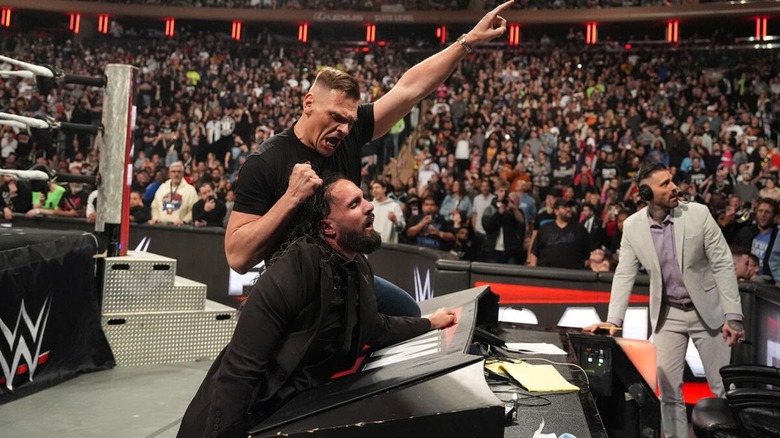 GUNTHER holds Seth Rollins mid-beatdown and points toward the WrestleMania sign during an episode of 