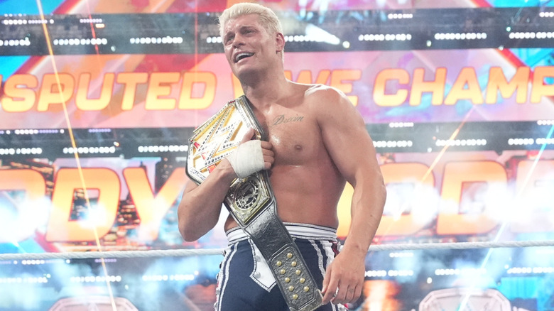 Cody Rhodes holds the Undisputed WWE Championship around his shoulder.