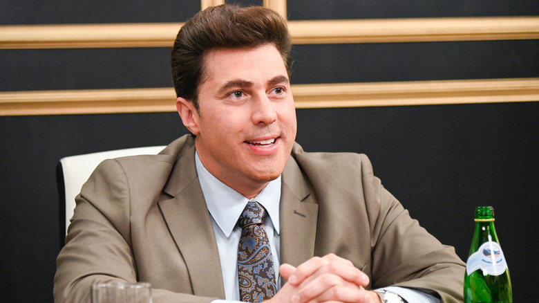 Adam Ray as Vince McMahon, sitting at desk
