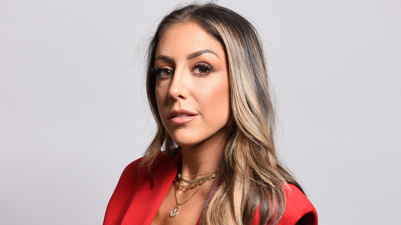 Britt Baker wearing a red jacket