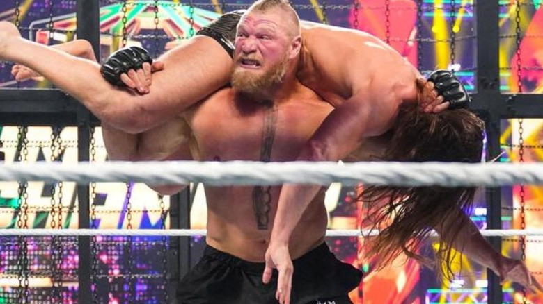 Brock Lesnar puts Matt Riddle over his shoulders in the ring during an Elimination Chamber match.