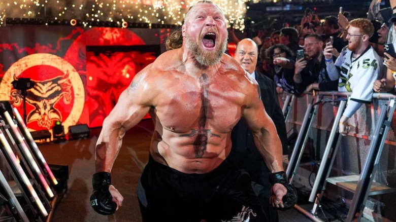 Brock Lesnar walks down the ramp to the ring, flanked by Paul Heyman, to get in the cage at Survivor Series: WarGames.
