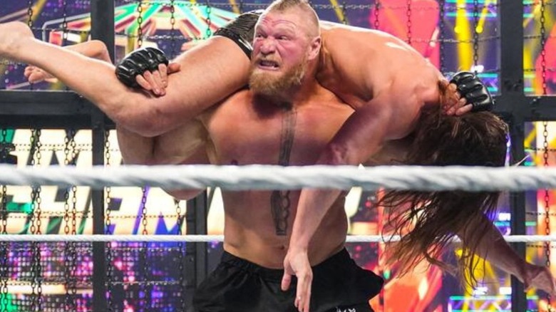Brock Lesnar puts Matt Riddle over his shoulders in the ring during an Elimination Chamber match.