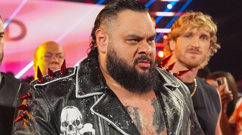 Bronson Reed, flanked by Austin Theory, Paul Heyman, and Logan Paul, makes his way down to the ring before a match on 