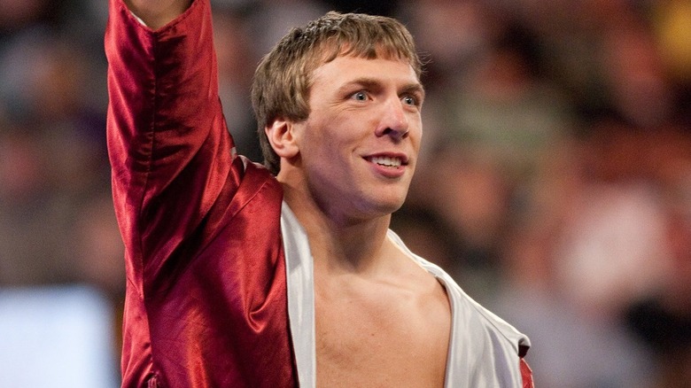 Daniel Bryan with a short haircut wearing a red robe