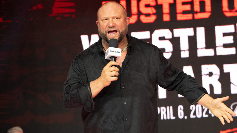 Bully Ray wearing a black button-up shirt and holding a mic
