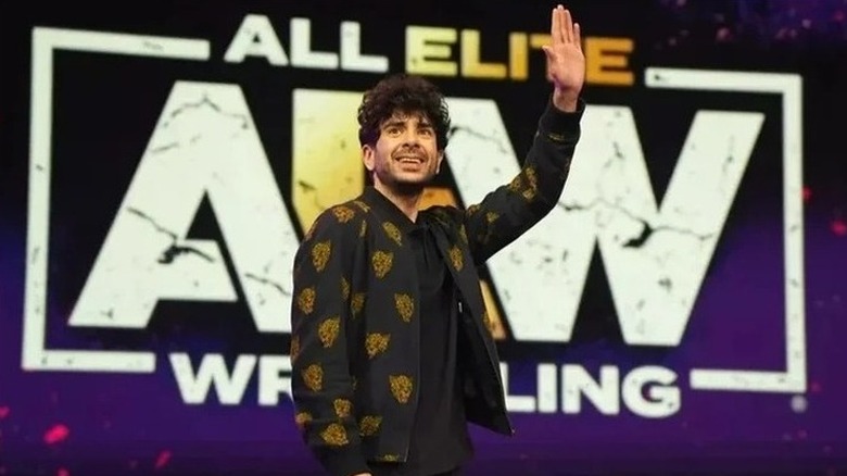 AEW President and CEO Tony Khan waves out towards the crowd during a live event.