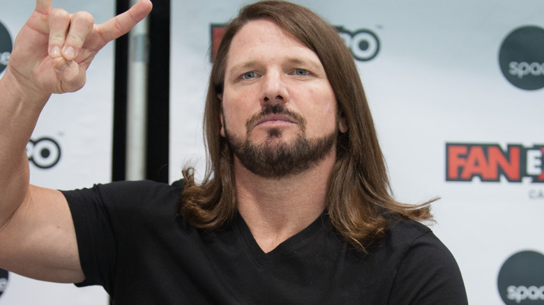 AJ Styles holding up a Too Sweet