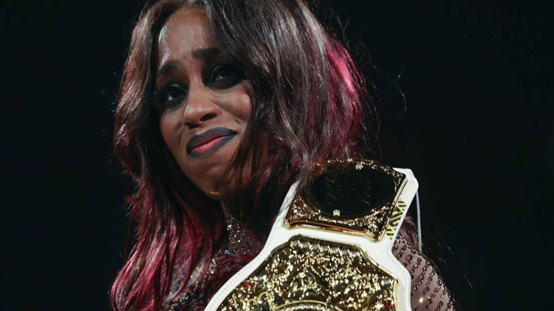 An emotional Naomi smiles toward the crowd ahead of her pregnancy announcement on an August 2025 edition of 