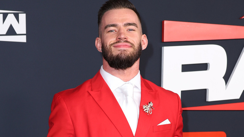 Austin Theory wearing a red suit jacket