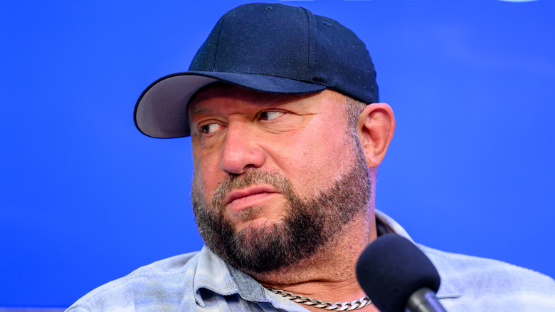 Bully Ray with a blue background, blue shirt, and blue hat