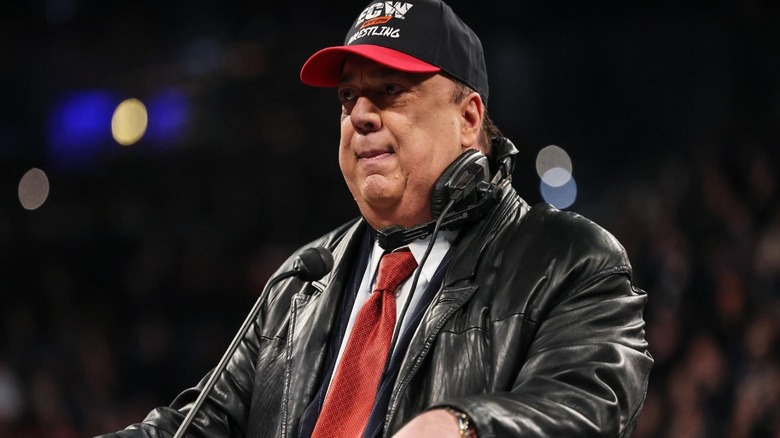 Paul Heyman stands in the ring in his ECW hat, and signature jacket and headset, during his 2024 WWE Hall of Fame induction speech.
