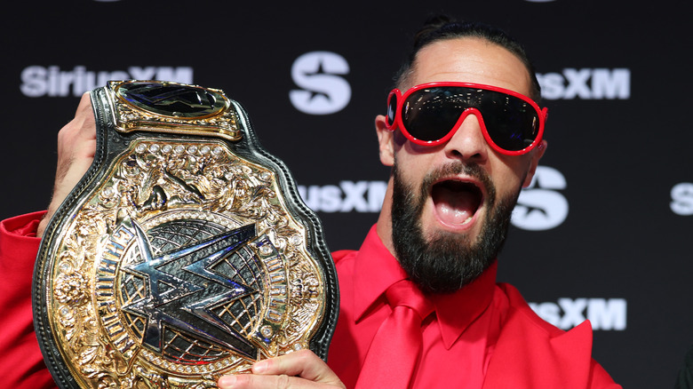 Seth Rollins holding up the WWE World Heavyweight Championship at a SiriusXM event