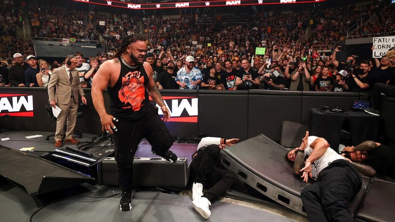 Jacob Fatu stands above the fallen forms of the Usos and Roman Reigns on 