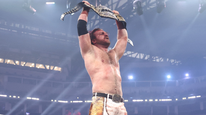 Hangman Adam Page holding up the AEW World Championship