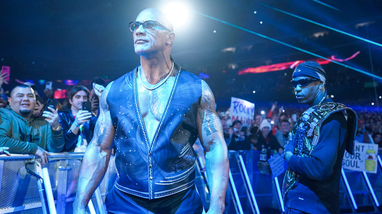 The Rock and Travis Scott stand in blue light