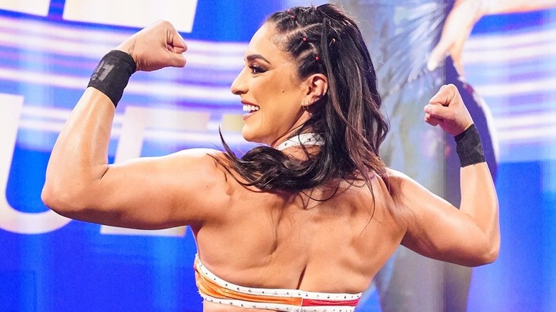 Raquel Rodriguez flexes her back muscles