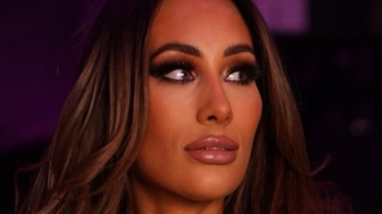Carmella poses backstage at a WWE show