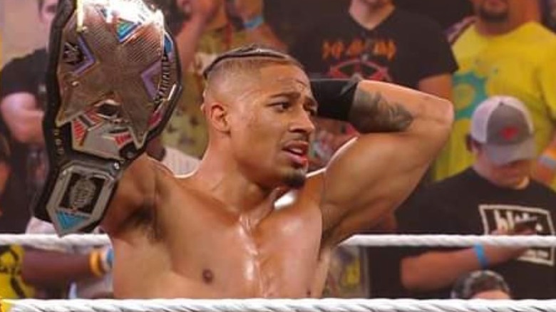 WWE NXT Champion Carmelo Hayes and challenger Wes Lee lay outside of the ring after going through the announcer's desk during their title match at Heatwave.