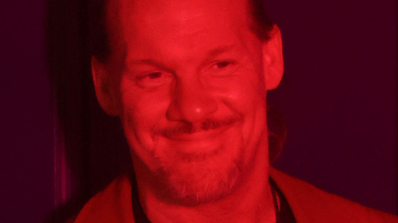 Chris Jericho smiling under red light