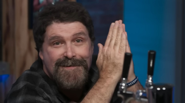 Mick Foley on his knees holding prayer hands