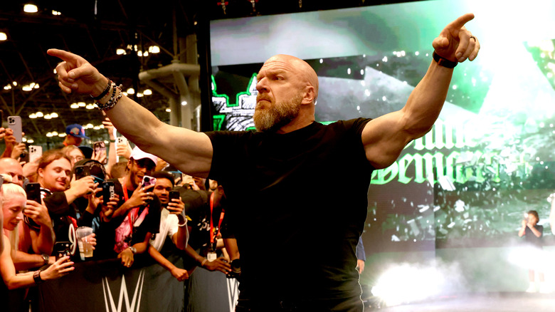 WWE CCO Triple H points out towards the crowd during a Fanatics Fest event