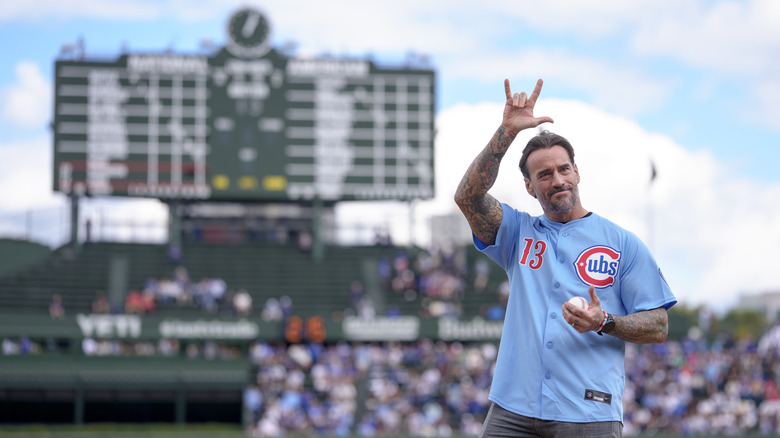 WWE star CM Punk gives the universal sign "I love you" to the Wrigley Field crowd in Chicago before throwing the first pitch at a Cubs game